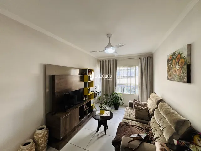 Sala de estar com sofá e painel de TV em um apartamento no Brasil.