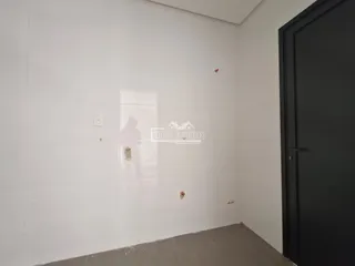Ambiente interno com paredes brancas e piso de concreto em uma residência.
