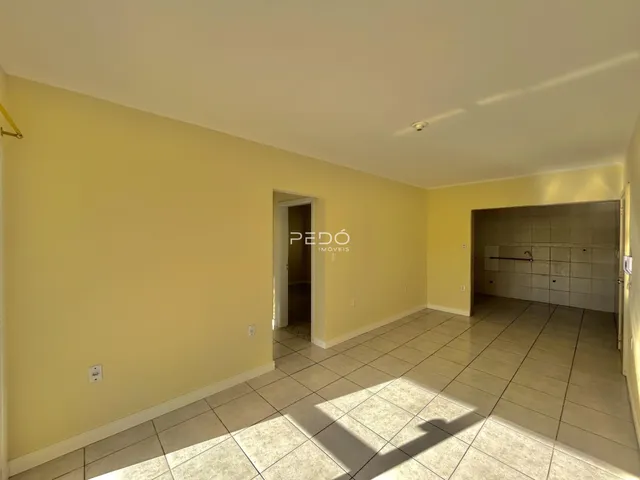 Vista interna de um ambiente com paredes amarelas e piso de cerâmica.