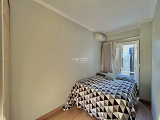 Quarto com cama e piso de madeira na residência.