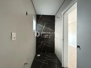 Hall de passagem com paredes brancas e piso de mármore preto na residência.