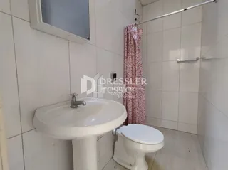 Foto do interior de um banheiro com azulejos brancos.