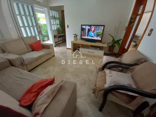 Sala de estar com sofás e portas de vidro que dão acesso ao exterior.