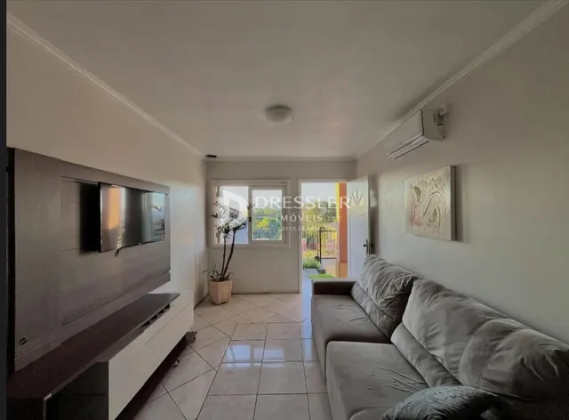 Ambiente interno de uma sala com paredes brancas e piso claro.