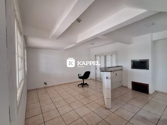 Sala de estar com piso de cerâmica e lareira em um imóvel em Lajeado.