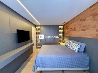 Este é um quarto moderno com cama e painel de televisão em um ambiente com paredes cinzas.