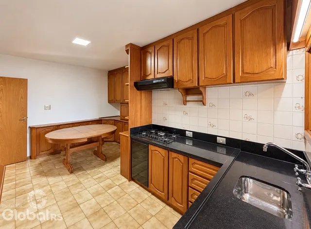 Foto interna de uma cozinha com armários de madeira e piso de cerâmica.