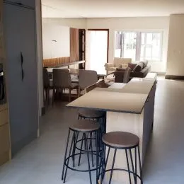 Cozinha moderna com balcão e banquetas em ambiente interno.
