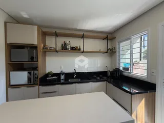 Vista da cozinha com armários de madeira e bancadas escuras.