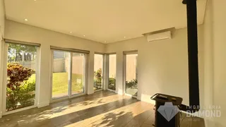 Sala de estar com piso de madeira e portas de vidro que dão para o jardim.