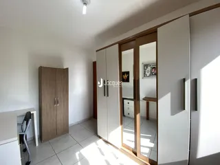 Interior de um cômodo com armários em madeira e piso de cerâmica.