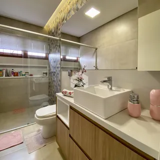 Foto de um banheiro moderno com box de vidro e bancada de madeira.
