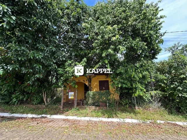 Fachada de uma residência em Lajeado, Brasil, com vegetação densa.