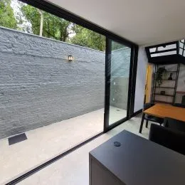 Vista de uma parede externa com uma grande janela preta em um imóvel em Lajeado.