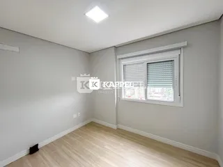 Foto de um cômodo interno com paredes cinzas e piso de madeira clara.