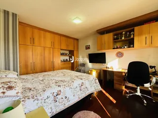 Quarto com armários de madeira e cama em um imóvel no Brasil.