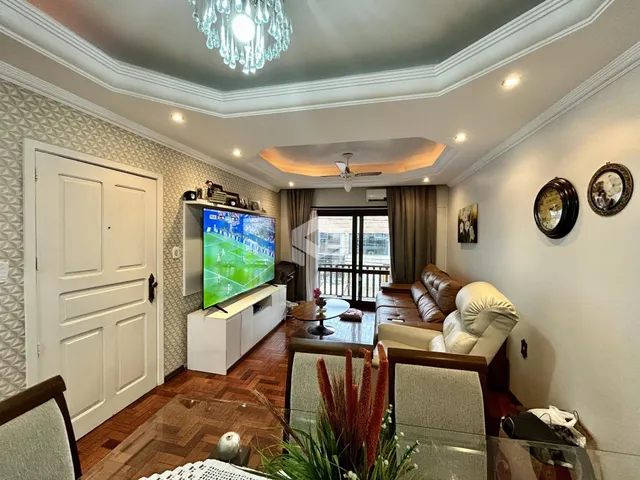 Sala de estar com piso de madeira e decoração de teto elaborada.