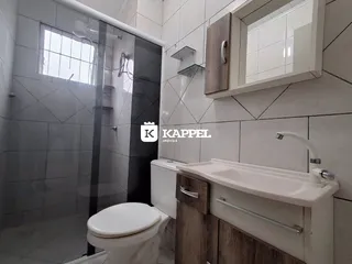 Banheiro com box de vidro e bancada de madeira.