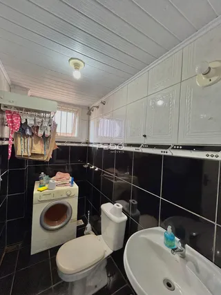 Uma foto de um banheiro com revestimento de azulejos preto e branco.