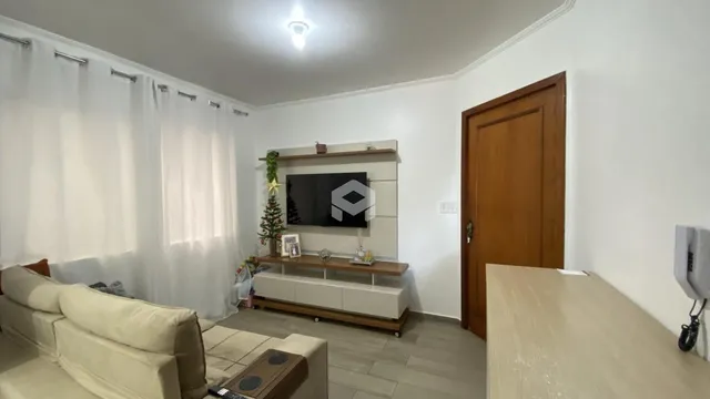 Sala de estar com sofá e painel de televisão na parede.