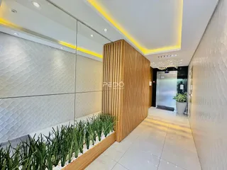 Hall de entrada moderno com revestimento de madeira e piso claro.