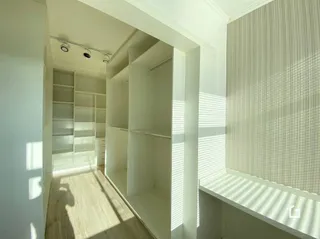 Hall com estantes embutidas e piso de madeira clara.