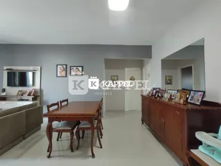 Foto de uma sala com mesa de jantar de madeira e espelho na parede.