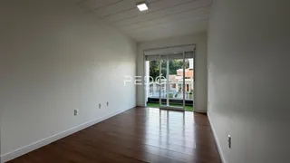 Vista interna de um ambiente com piso de madeira e porta de vidro.