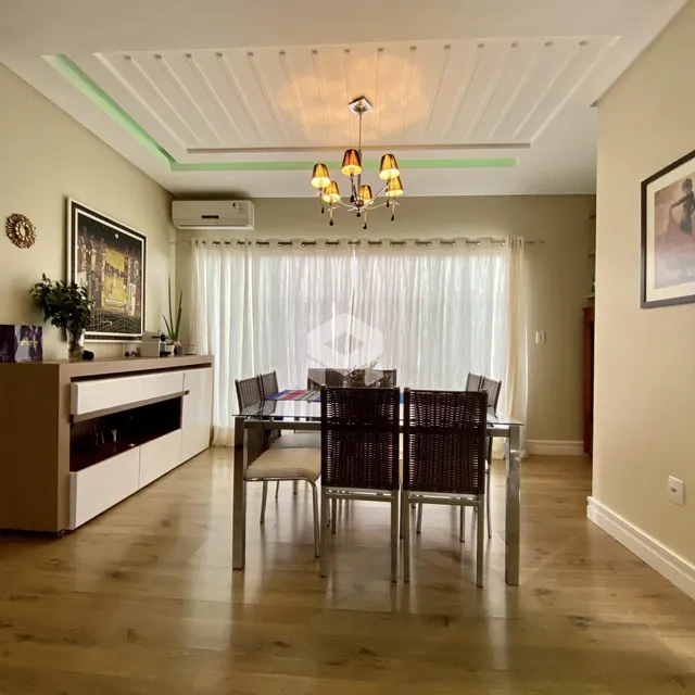 Uma sala de jantar com mesa e cadeiras em um ambiente claro.