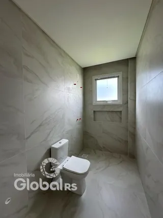 Foto de um banheiro com piso e paredes revestidos de cerâmica.