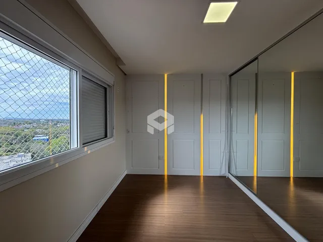 Interior de um ambiente com piso de madeira e grande janela.