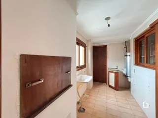 Foto interna de um banheiro com piso de cerâmica e detalhes em madeira.