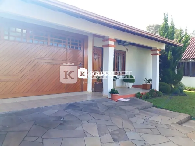 Fachada frontal de uma residência com garagem e área externa pavimentada.