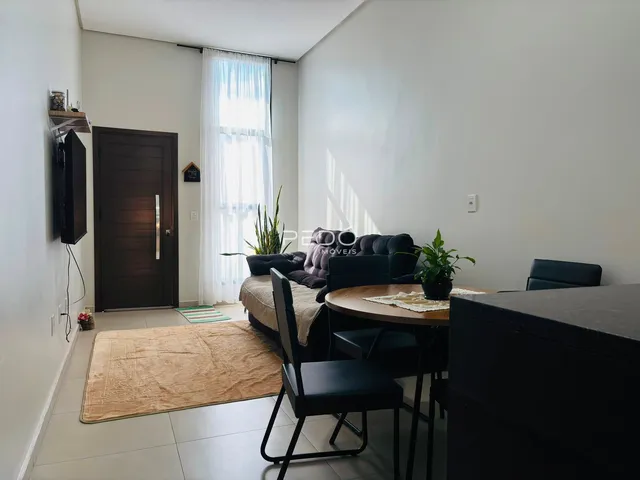Sala de estar com sofá e mesa de jantar em ambiente claro.