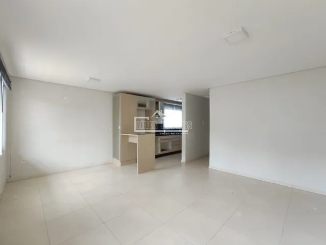 Ambiente interno de uma sala ampla com piso de cerâmica clara.