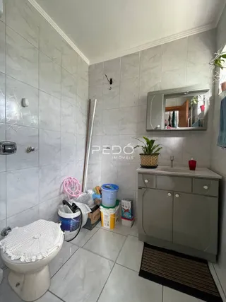 Foto de um banheiro com revestimento cerâmico branco.