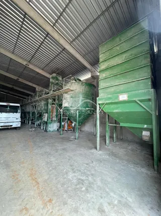 Foto de um espaço industrial com estrutura metálica e piso de concreto.