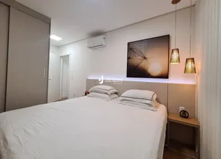 Quarto com cama de casal e paredes brancas.