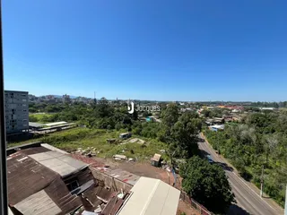Vista aérea de uma área com vegetação e estruturas em ruínas no entorno de uma estrada.