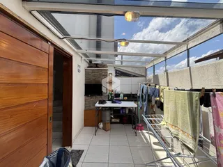 Ambiente interno com teto de vidro e área de serviço visível na propriedade.