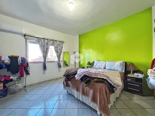 Quarto com cama e parede verde em um imóvel no Brasil.