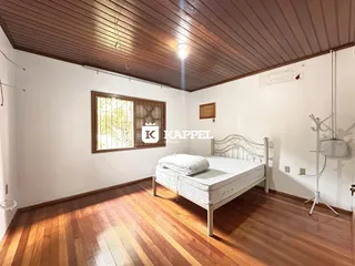 Quarto com cama de madeira e piso de madeira.
