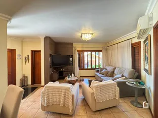 Sala de estar com sofá e portas de madeira em uma residência no Brasil.