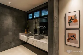 Banheiro com bancada de mármore e pias duplas.