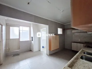 Vista interna de uma sala com piso de cerâmica e janela.