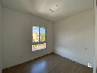 Ambiente interno com piso de madeira e janela iluminada.