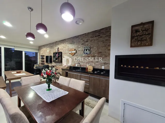 Ambiente interno de sala de jantar com parede de tijolos aparentes.