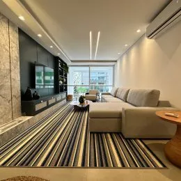 Uma sala de estar moderna com sofá e painel escuro.