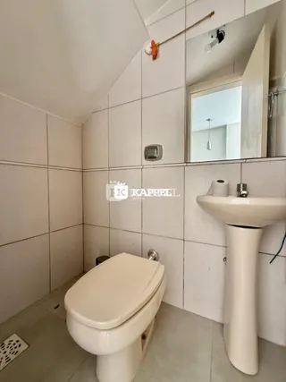 Foto de um banheiro com paredes brancas e piso de cerâmica.
