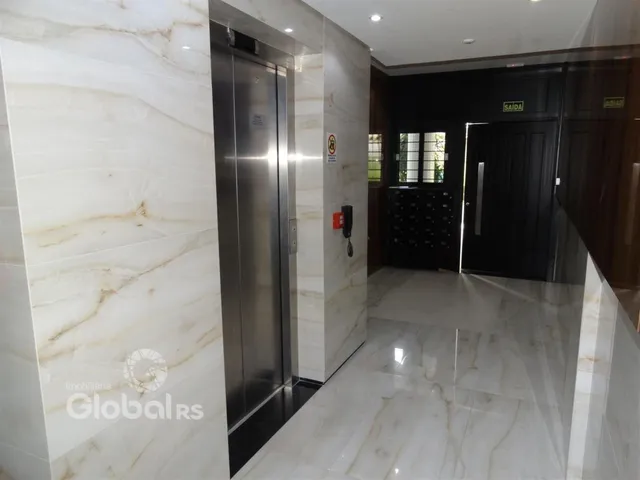 Hall de entrada com revestimento de mármore e piso brilhante.